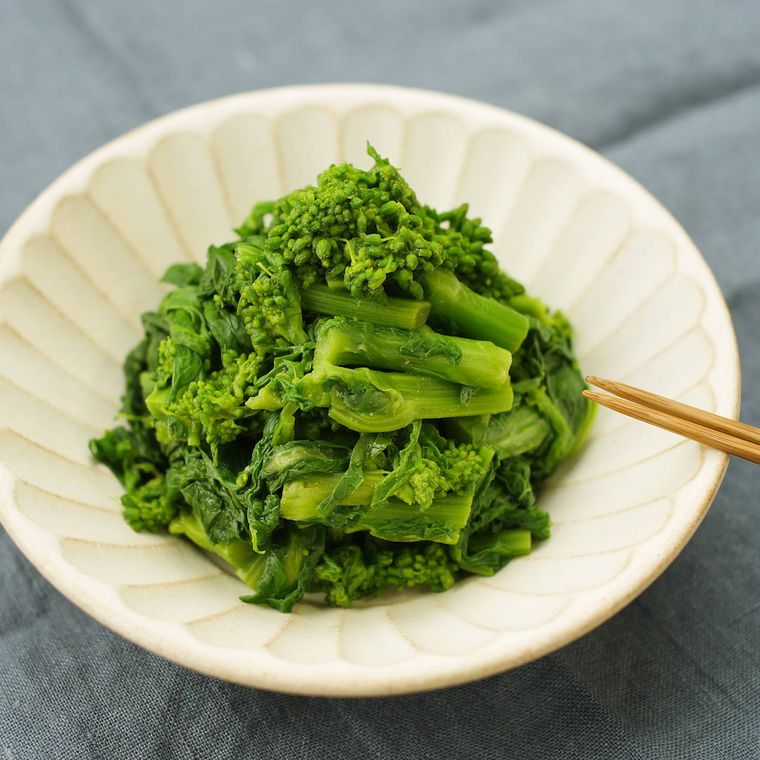 白くて丸いお皿に盛られた菜の花のからし和え
