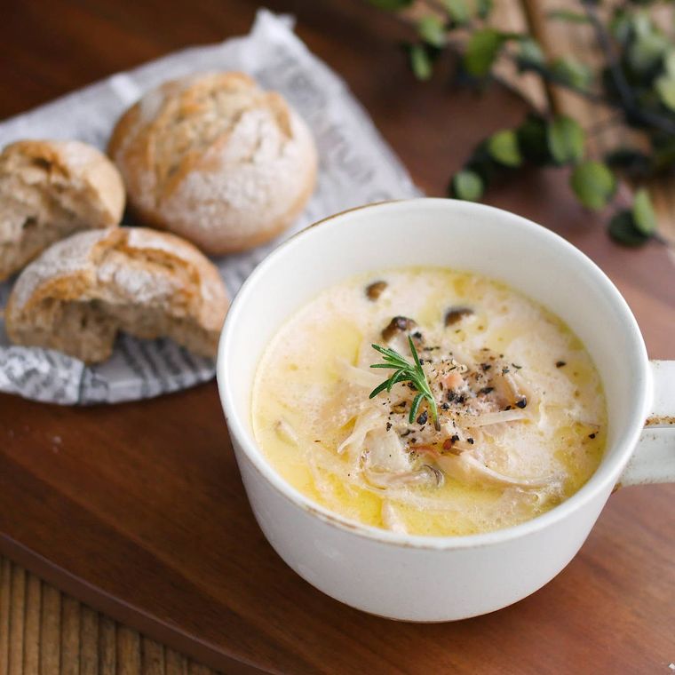 白いカップにたまねぎときのこのスープが入っている