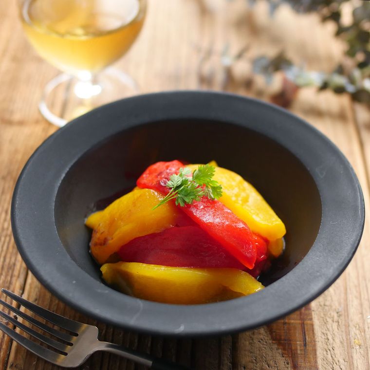 黒い皿に盛り付けられた焼きパプリカのマリネ