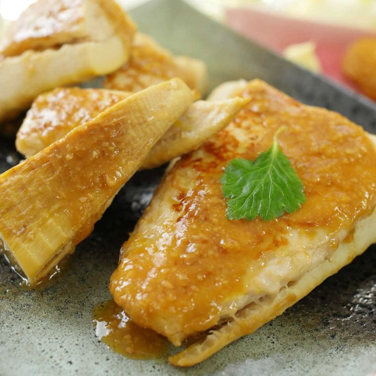 グレーのプレートに盛り付けられたみそだれのかかったたけのこ肉詰め