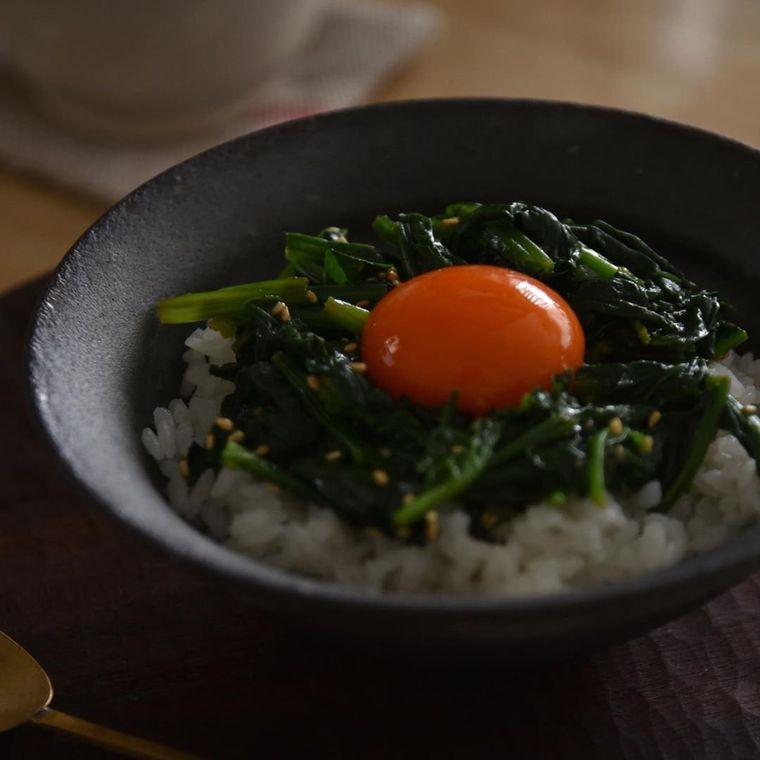 ほうれん草のナムルと卵黄がご飯に乗っている写真