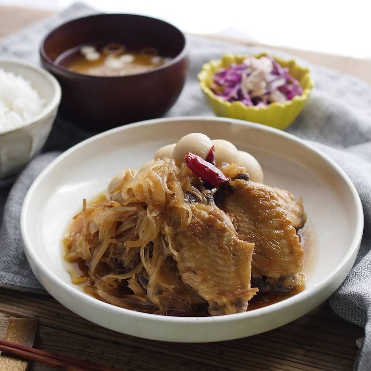 白い皿に盛り付けられた酢たまねぎと手羽中の煮物