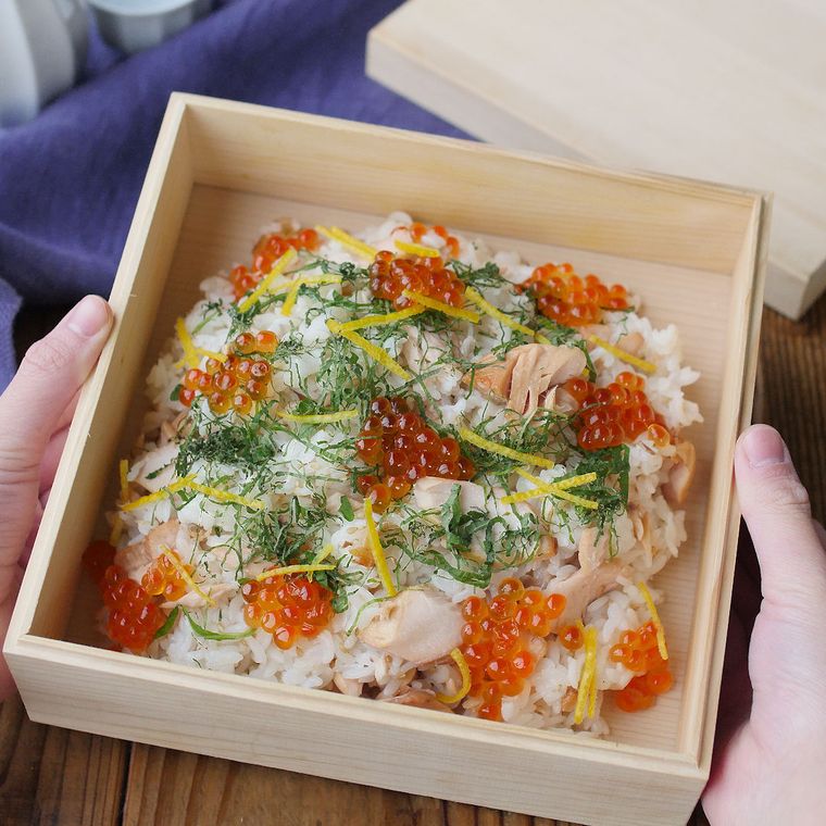 白木の箱に鮭といくらのちらし寿司が入っている