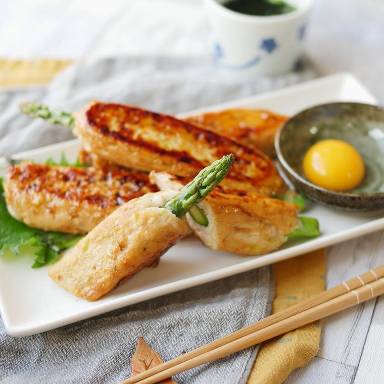 白い長方形のプレートに盛り付けられたアスパラ鶏つくね