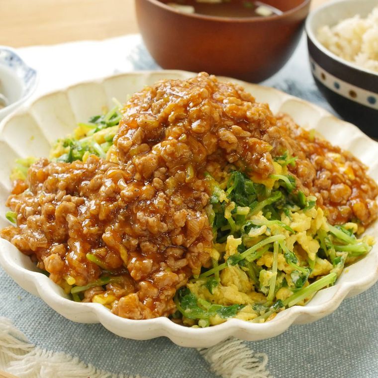 白い花型のお皿に盛り付けられた豆苗と卵のチリそぼろあんかけ