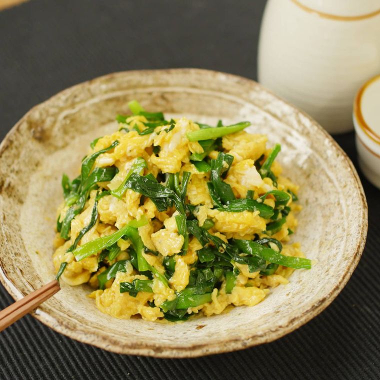 ベージュの和食器に盛りつけれられたふわふわ卵のにら玉炒め