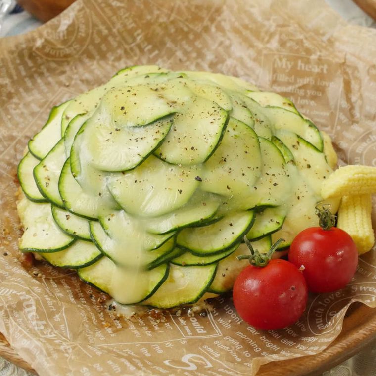 皿に盛られた豚こま肉とズッキーニのもりもりピザ