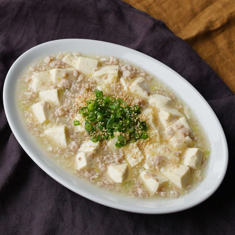 白い皿に盛られたネギとごまを散らした、辛くない塩麻婆豆腐