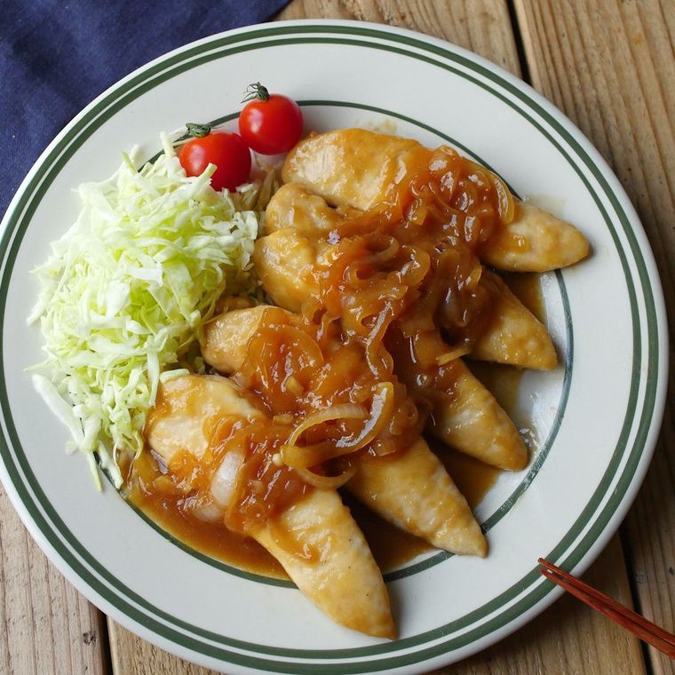 黒いラインの入りの白い丸プレートに盛り付けられたまるごとささみのバターしょうが焼き