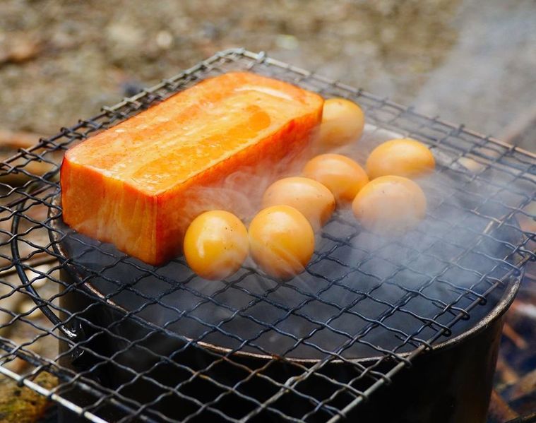 ベーコンとうずらの卵が燻製されている様子