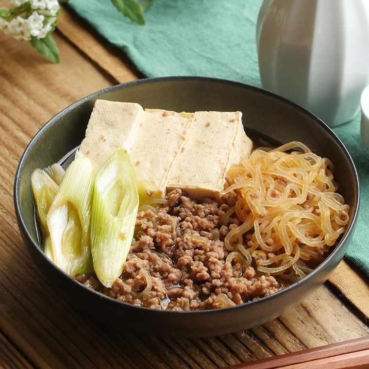黒色の椀に盛り付けられたひき肉としらたきの肉豆腐