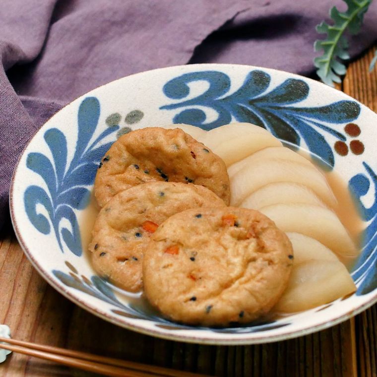 青いリーフ模様の皿に盛られたがんもどきと大根の煮物