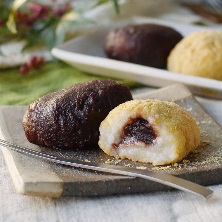 グレーの四角いプレートに乗っているこしあんときな粉のおはぎとフォーク