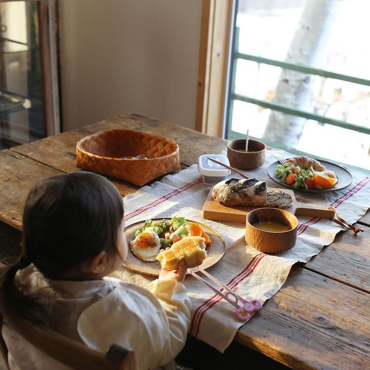 窓の外を見ながらご飯を食べている子供