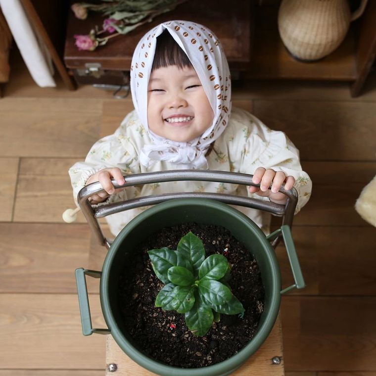 椅子の背もたれに手を置いて笑っている子供