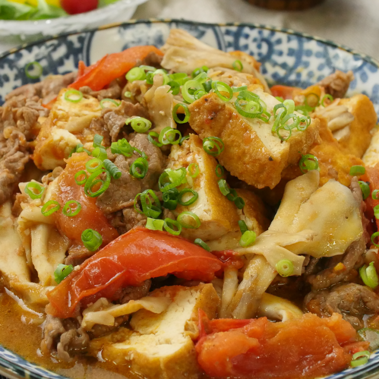 青い小花柄の皿に盛られた、牛肉ときのこのトマト煮込み