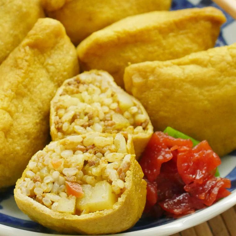 白と青の市松模様が描かれた丸皿に盛り付けたカレーいなり寿司