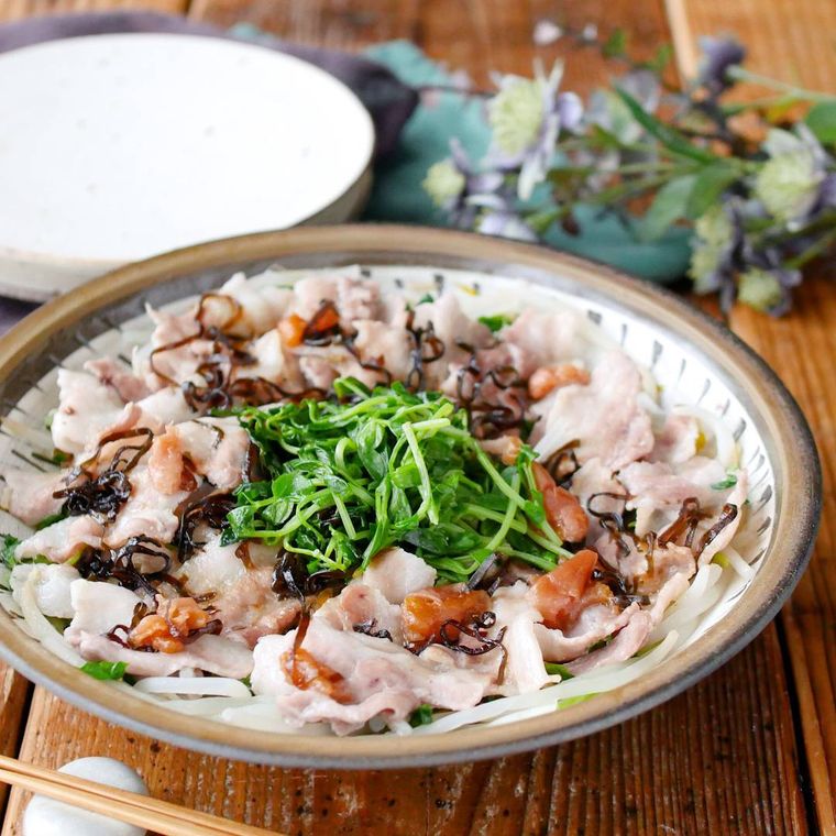 白色に茶色の縁の皿に盛りつけられたさっぱり！豚バラ肉と豆苗ともやしの梅レンジ蒸し