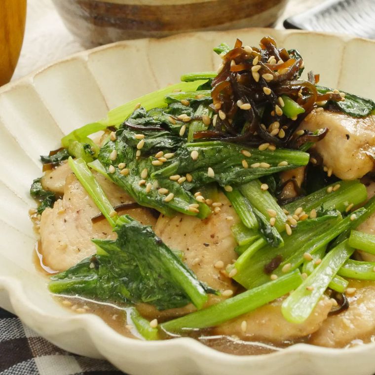 白い花型のお皿に盛り付けられた鶏むね肉と小松菜のバター塩昆布炒め