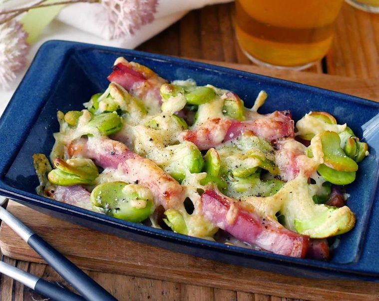 紺色の皿に盛られたそら豆とベーコンのカリカリチーズ焼き