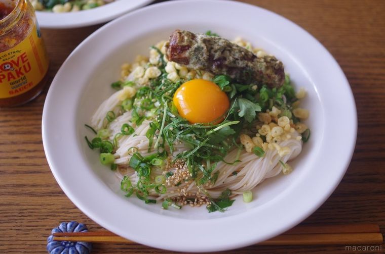 白い皿に盛り付けた磯辺揚げ、卵黄、薬味がのったぶっかけそうめん