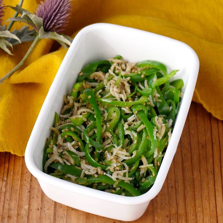 白い容器に盛りつけられたピーマンとしらすのめんつゆ炒め