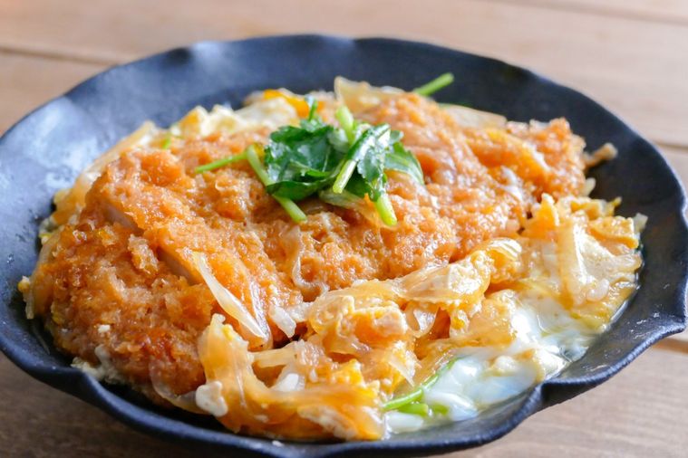 黒い丼に盛りつけられたカツ丼