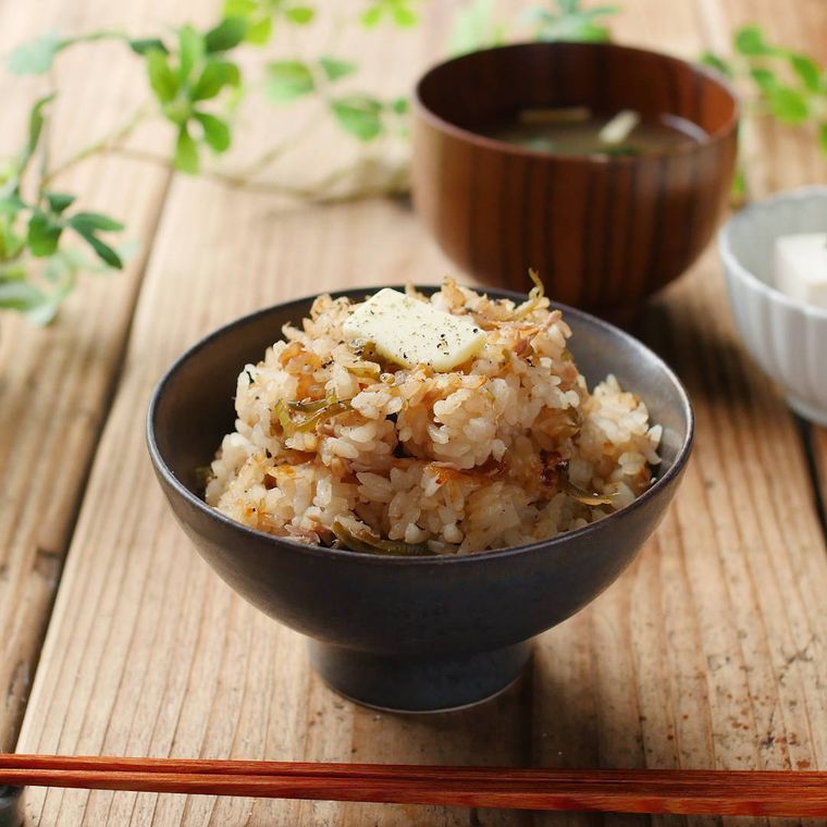 黒い茶碗によそったシーチキンのバターごはん