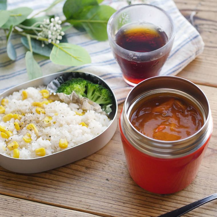 赤いスープジャーに入ったハッシュドポークと、弁当箱に詰められたコーンバターライス