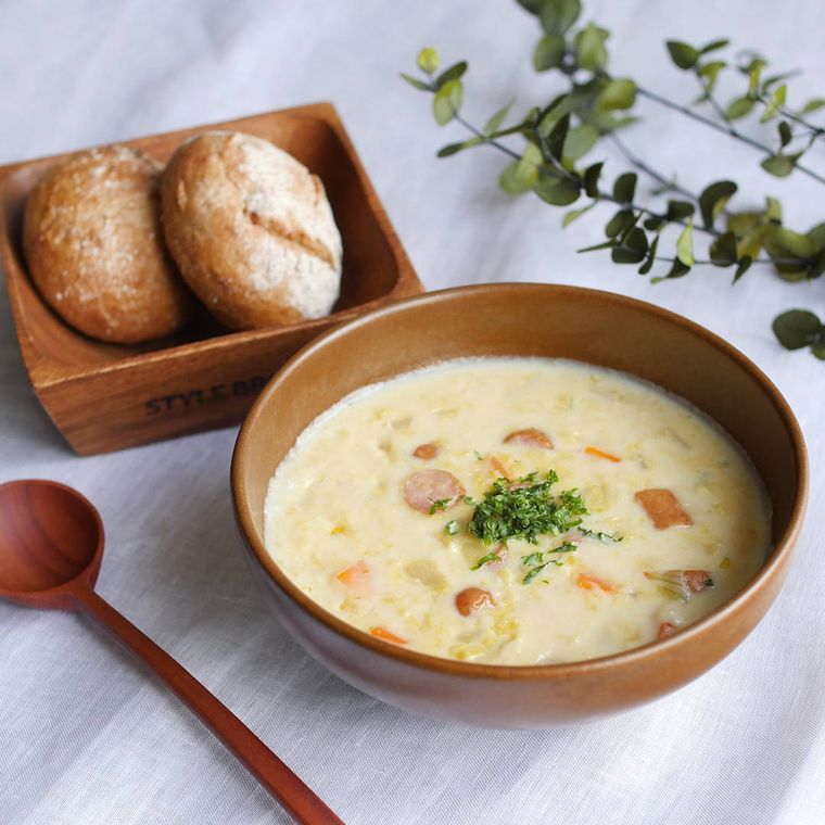 茶色い器に盛られた野菜とウインナーのコーンスープ