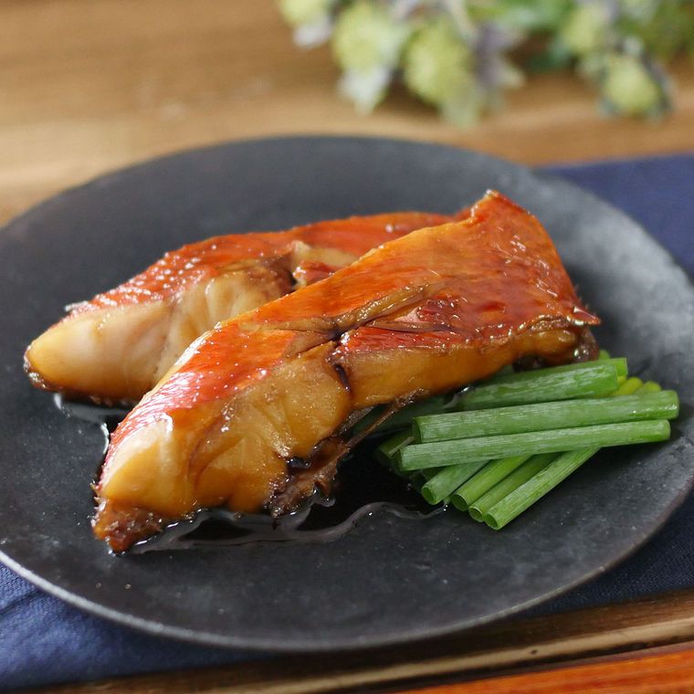 黒い皿に盛りつけた金目鯛の煮付け