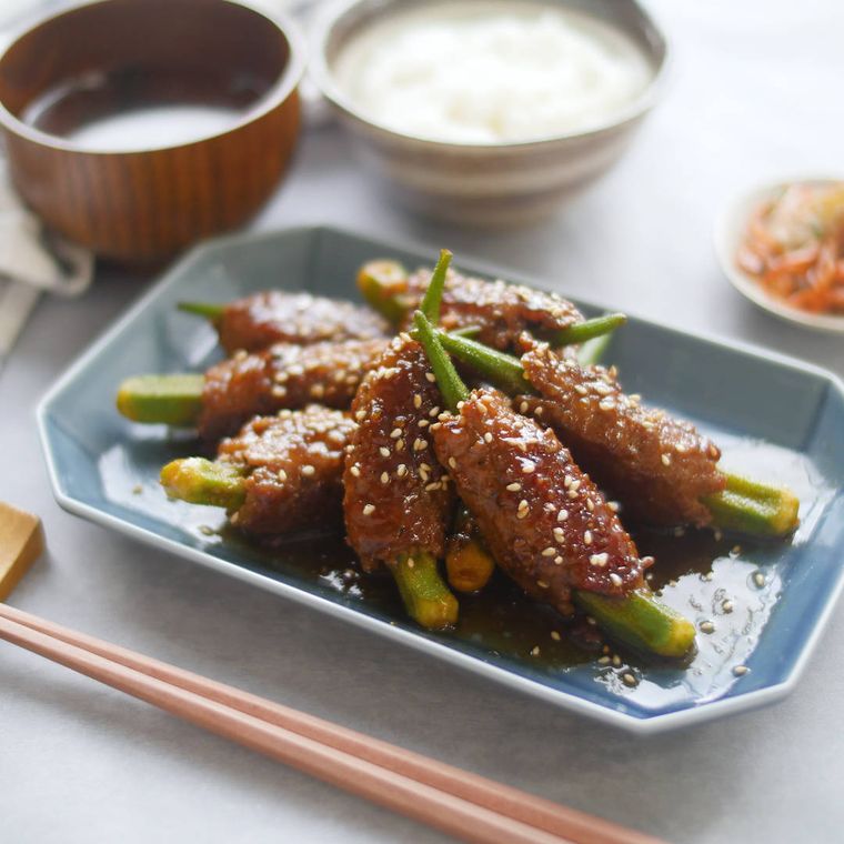 水色の四角い皿に盛り付けられているオクラのひき肉包み焼き