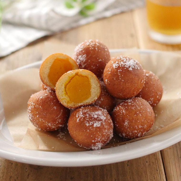 白い皿に盛られた、カボチャあんドーナツ