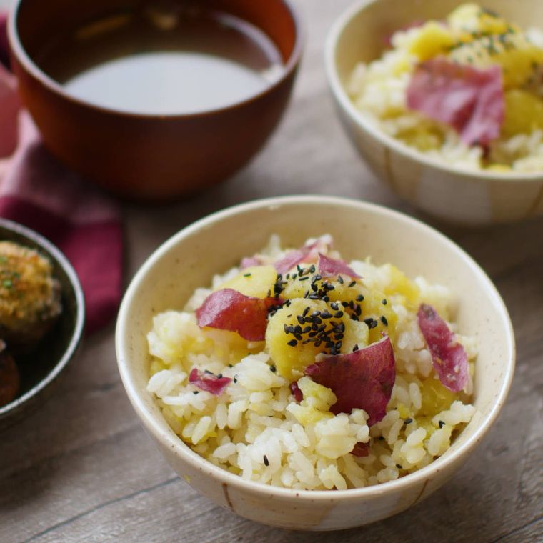 白いお茶碗によそったさつまいもの炊き込みごはんに、味噌汁が添えられている様子
