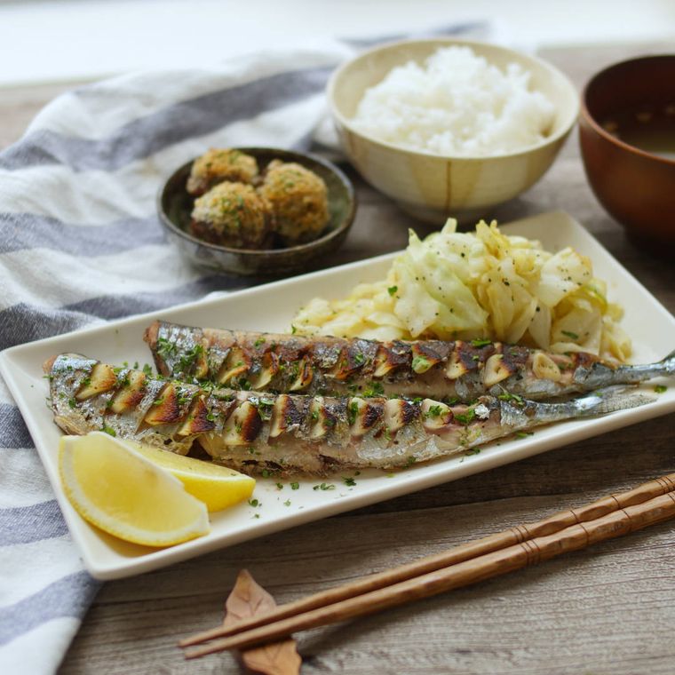 白い角皿に盛り付けたさんまのガーリック焼きに、ごはんと味噌汁が添えられている様子