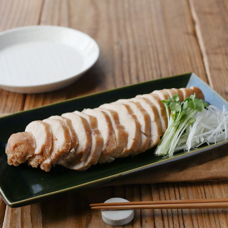 黒い角皿に盛り付けたしょうゆと砂糖の胸肉チャーシュー