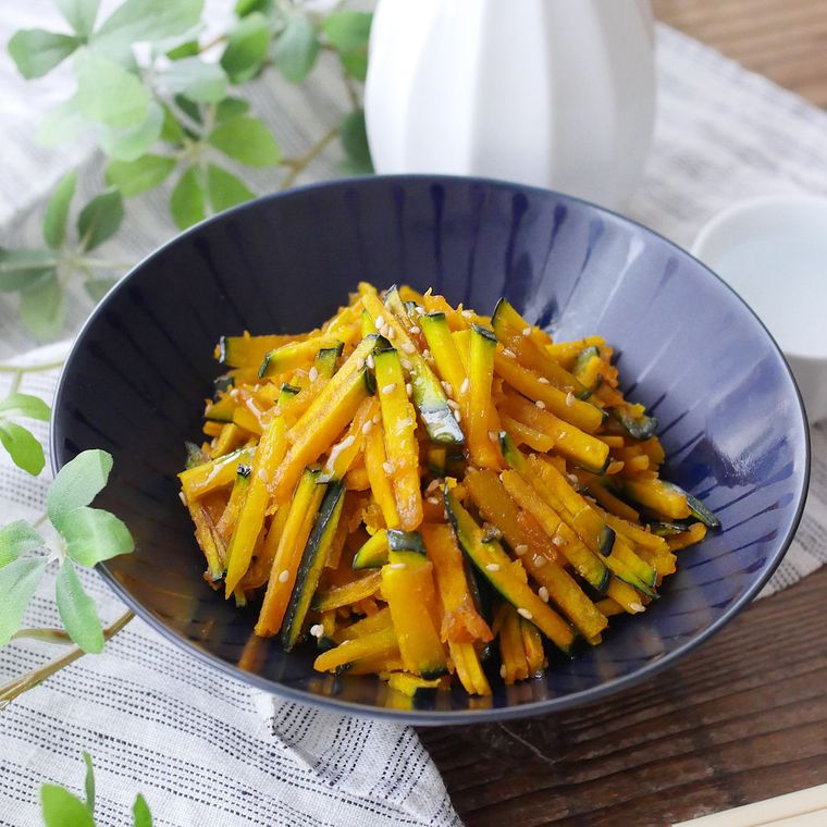 黒い丸皿に盛り付けられたかぼちゃきんぴら