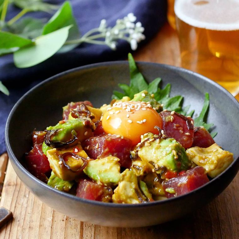 黒い皿に盛られたまぐろとアボカドのピリ辛和え