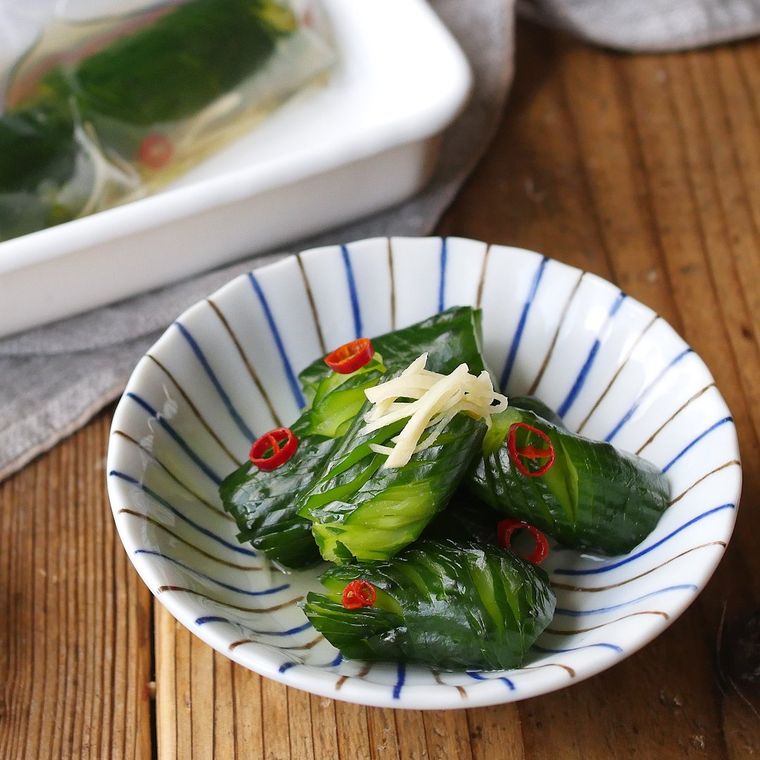 青と茶色のラインが入った白い小皿に盛り付けた、きゅうりの白だし浅漬け