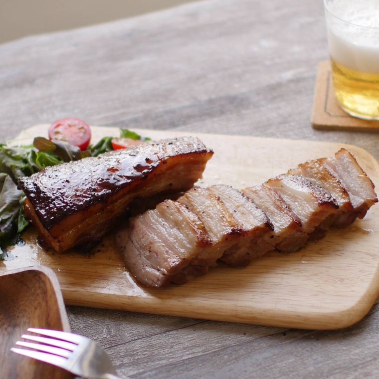 木製のカッティングボードに盛り付けた黒こしょうチャーシュー