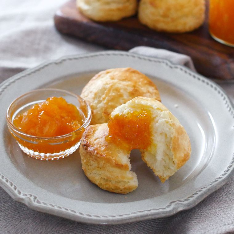 白い皿に盛り付けられたスコーンとみかんジャム