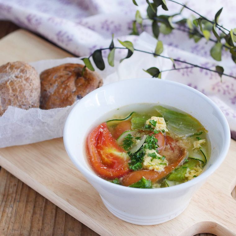 器に盛り付けられたトマトとレタスのコンソメスープ