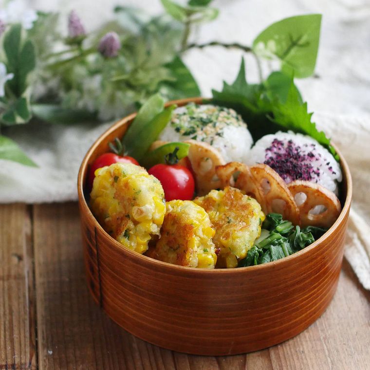 とうもろこしチーズはんぺん、おにぎり、プチトマトなどが入ったまげわっぱのお弁当