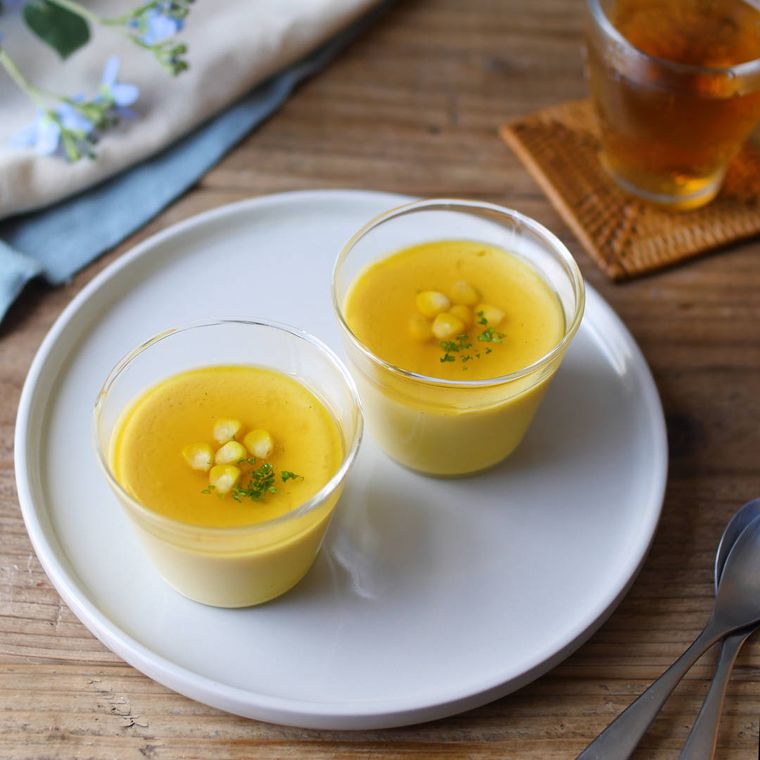 白い皿にのった、ガラスの器に入ったとうもろこしの冷やし茶碗蒸し