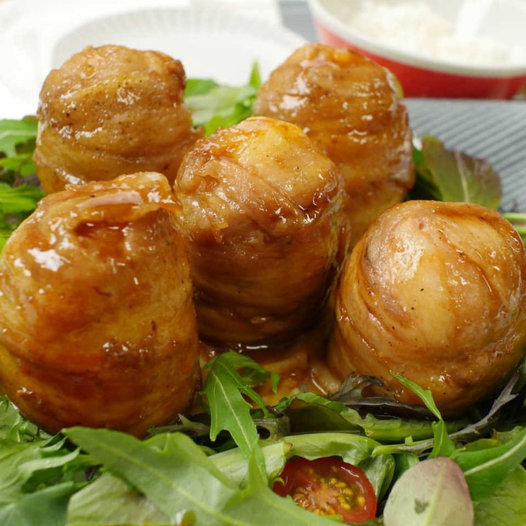 生野菜を敷いた皿に盛り付けた肉巻きゆで卵