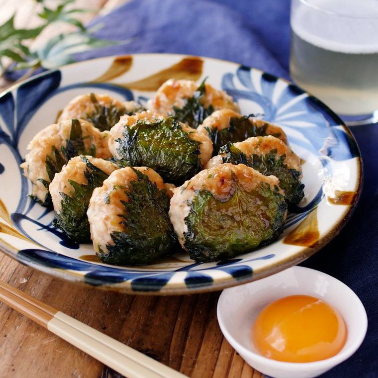 皿に盛られた大葉の照り焼き鶏つくねと小皿に入った卵黄