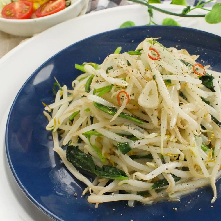 青い皿に盛りつけられたもやしとほうれん草のペペロンチーノ