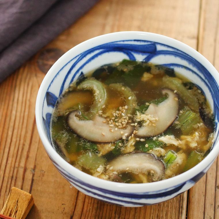 青と白の器にチンゲン菜としいたけのスープがはいっている様子