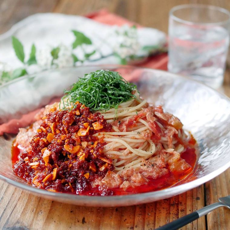透明の丸皿に盛られたトマトのピリ辛冷製パスタ