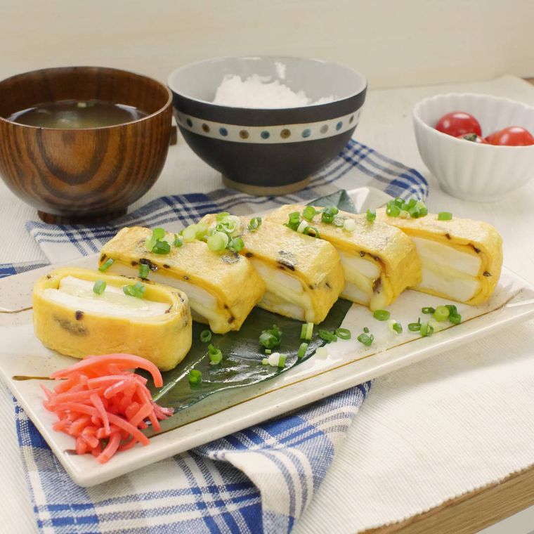 白い器に盛られたはんぺんのだし巻き卵に、ご飯、みそ汁、ミニトマトが添えられている様子